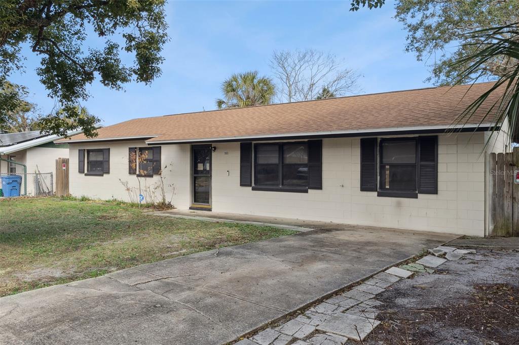 A single-story house with a concrete block exterior, a brown roof, and a concrete driveway — 1953 LINDA AVENUE, ORMOND BEACH, FL
