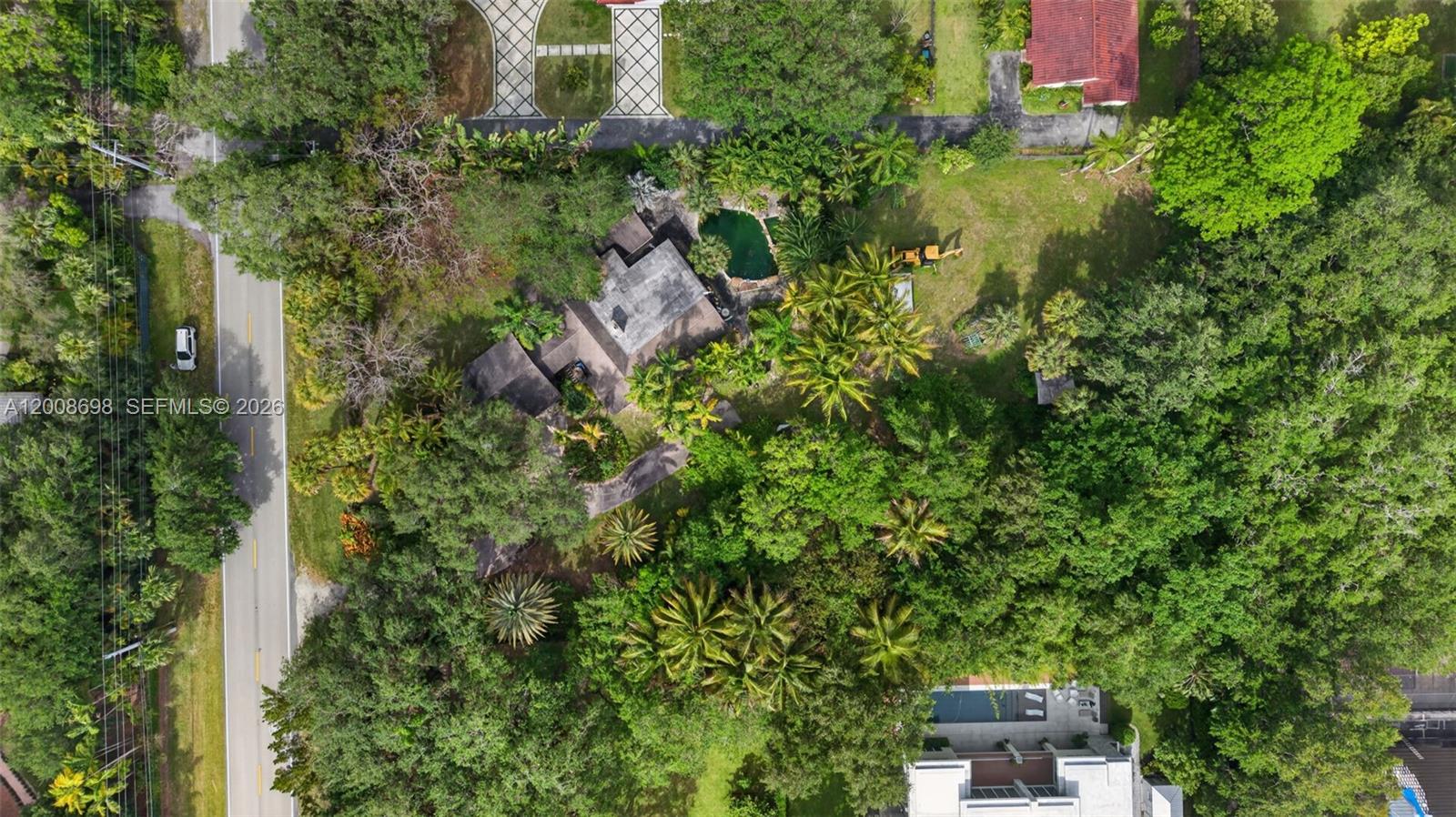 An aerial view shows a house with a pool surrounded by dense trees and vegetation — 8339 SW 112th St, Miami FL 33156, MIAMI, FL