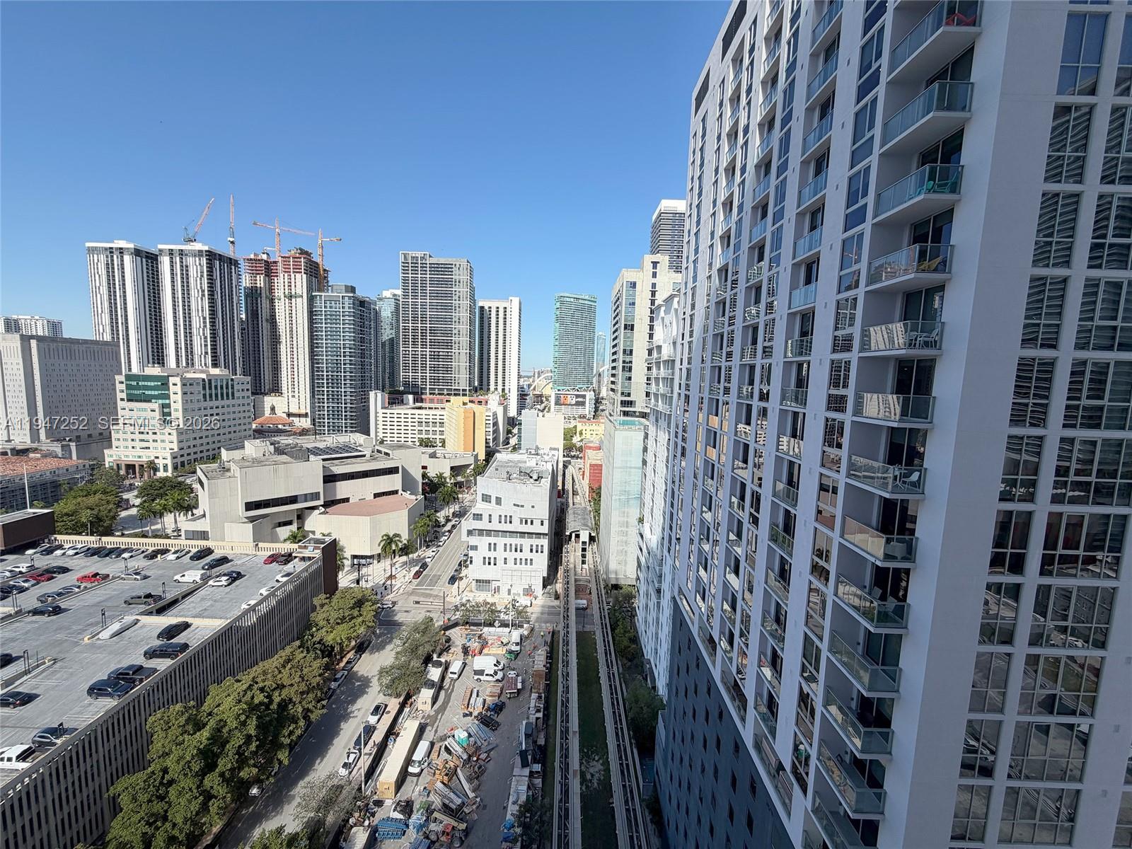 An elevated view shows a city skyline with high-rise buildings, a parking garage, and train tracks — 133 NE 2nd Ave # 2107, Miami FL 33132, MIAMI, FL