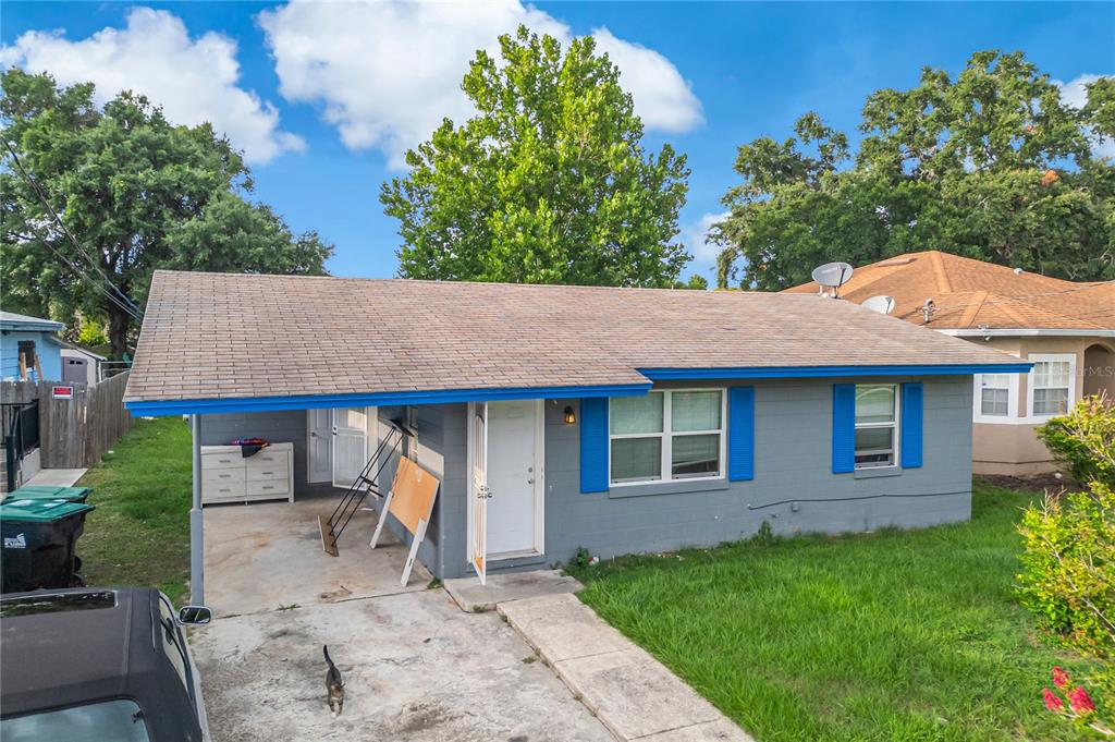A single-story gray house with a carport, blue trim, and a concrete driveway — 4135 RALEIGH STREET, ORLANDO, FL