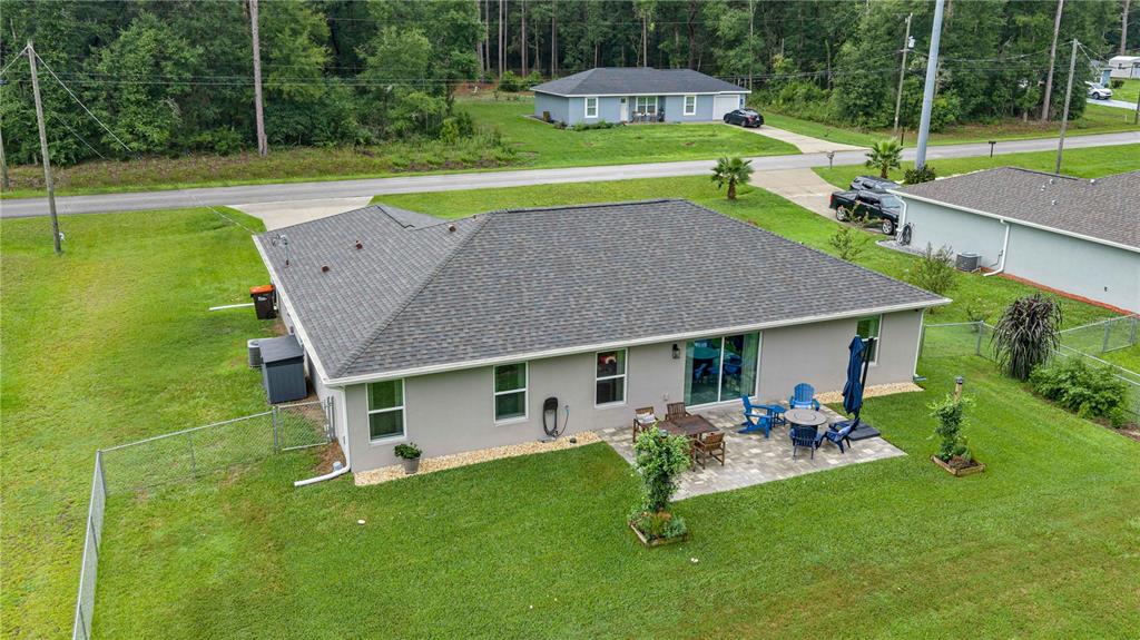 An aerial view of a gray house with a patio and a fenced backyard — 19855 SW 59TH LANE, DUNNELLON, FL