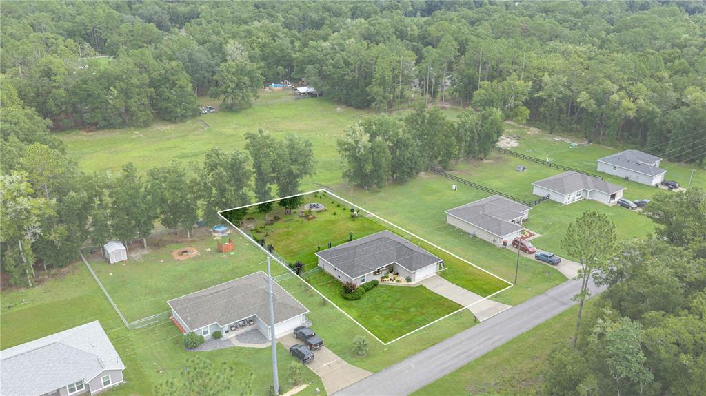 An aerial view shows a single-story house with a fenced backyard on a grassy lot — 19855 SW 59TH LANE, DUNNELLON, FL