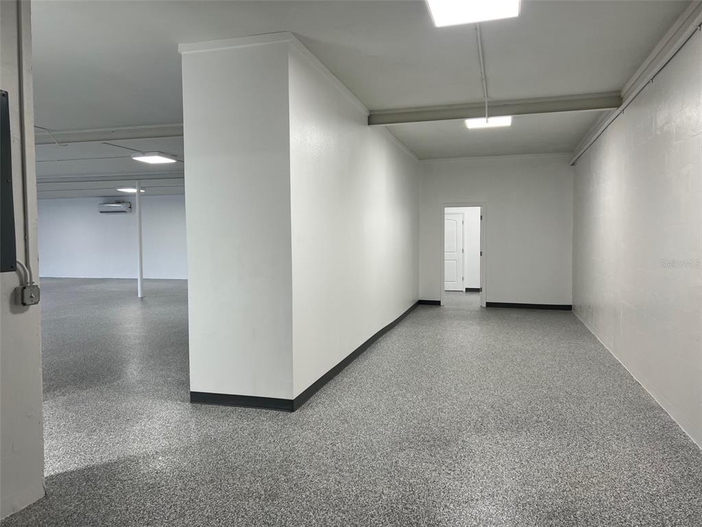 A large, open room with white walls, a gray speckled floor, and overhead lighting — 1710 N FORT HARRISON AVENUE, CLEARWATER, FL