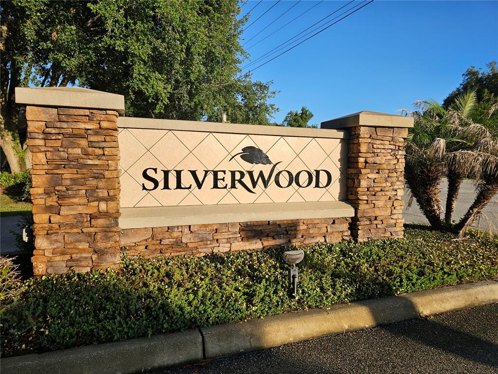 A stone and stucco monument sign for Silverwood stands in a landscaped area — 34224 SHADEWOOD CIRCLE, LEESBURG, FL