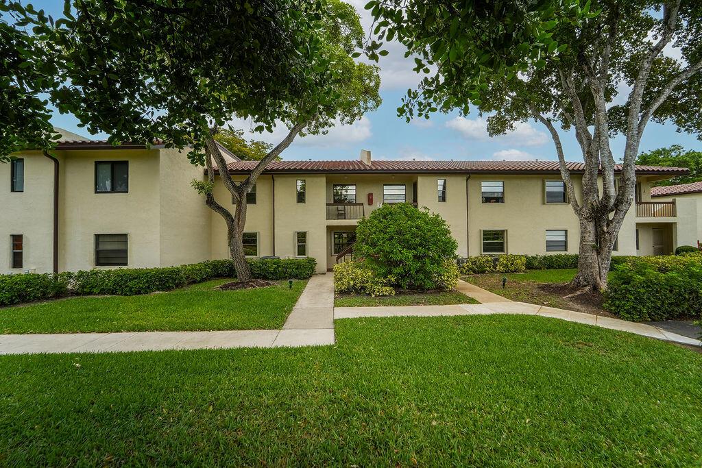 A two-story apartment building with a beige stucco exterior and a tiled roof — 21839 Arriba # 10g, Boca Raton FL 33433, BOCA RATON, FL