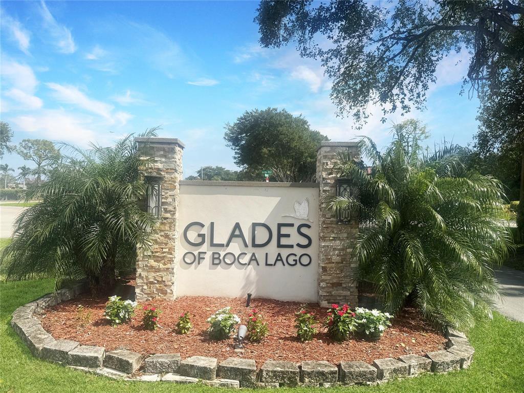 A stone-accented monument sign for Glades of Boca Lago stands in a landscaped garden — 21839 Arriba # 10g, Boca Raton FL 33433, BOCA RATON, FL