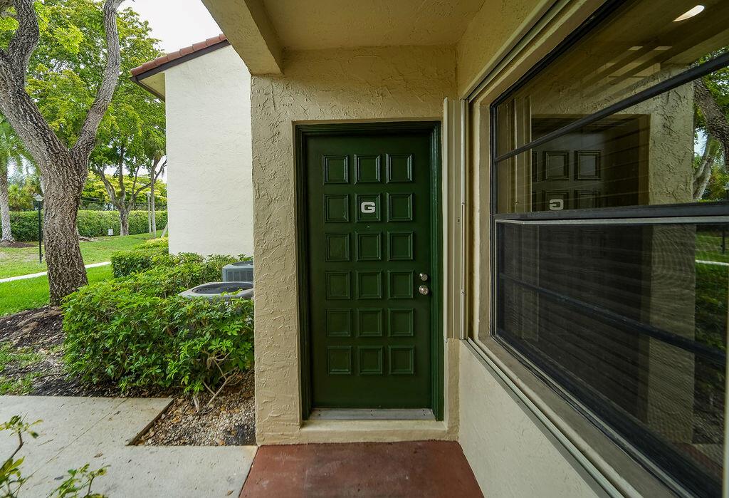 A green front door with a letter G sign sits under a covered entryway — 21839 Arriba # 10g, Boca Raton FL 33433, BOCA RATON, FL
