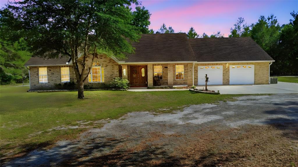 A single-story brick house with a two-car garage and a large front yard — 1640 RED DOG ROAD, DE LEON SPRINGS, FL