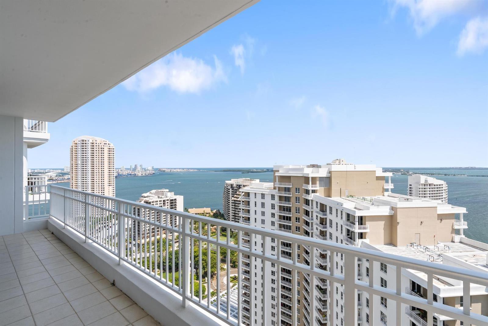 A high-rise balcony overlooks a bay with several large apartment buildings and a blue sky — 801 Brickell Key Boulevard # 2903, Miami FL 33131, MIAMI, FL