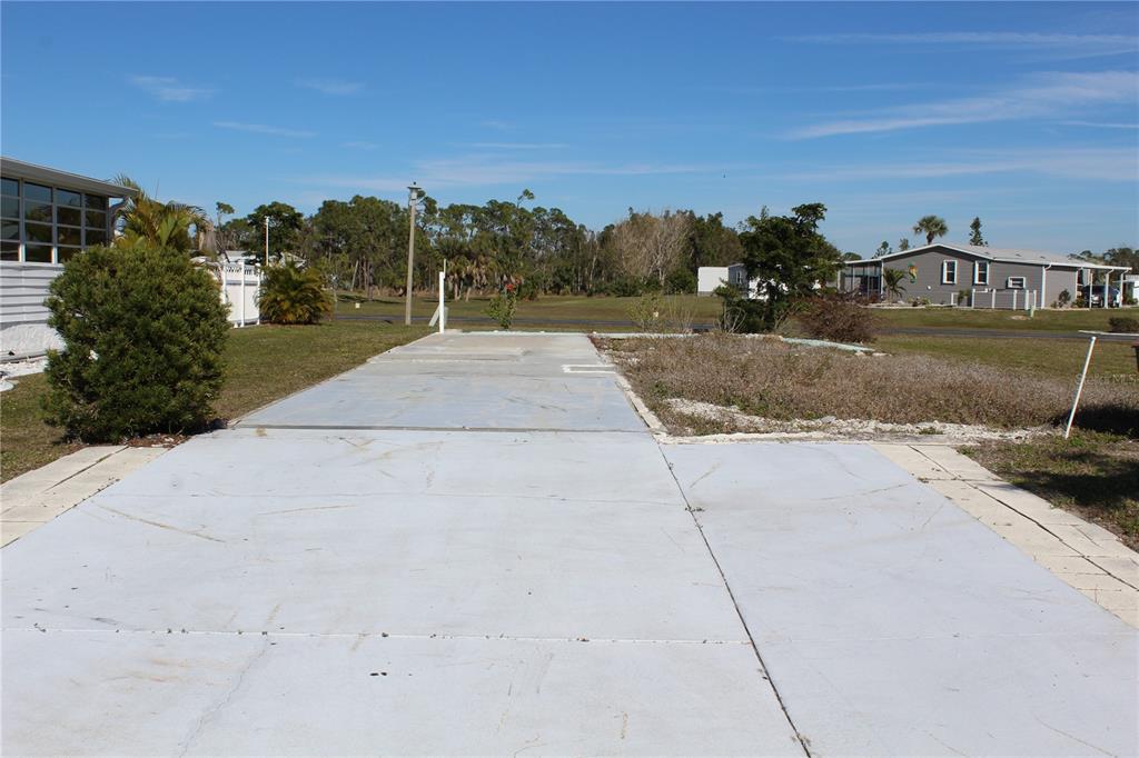 A concrete pad sits on a vacant lot next to a residential home — 7392 HESTON STREET, PORT CHARLOTTE, FL