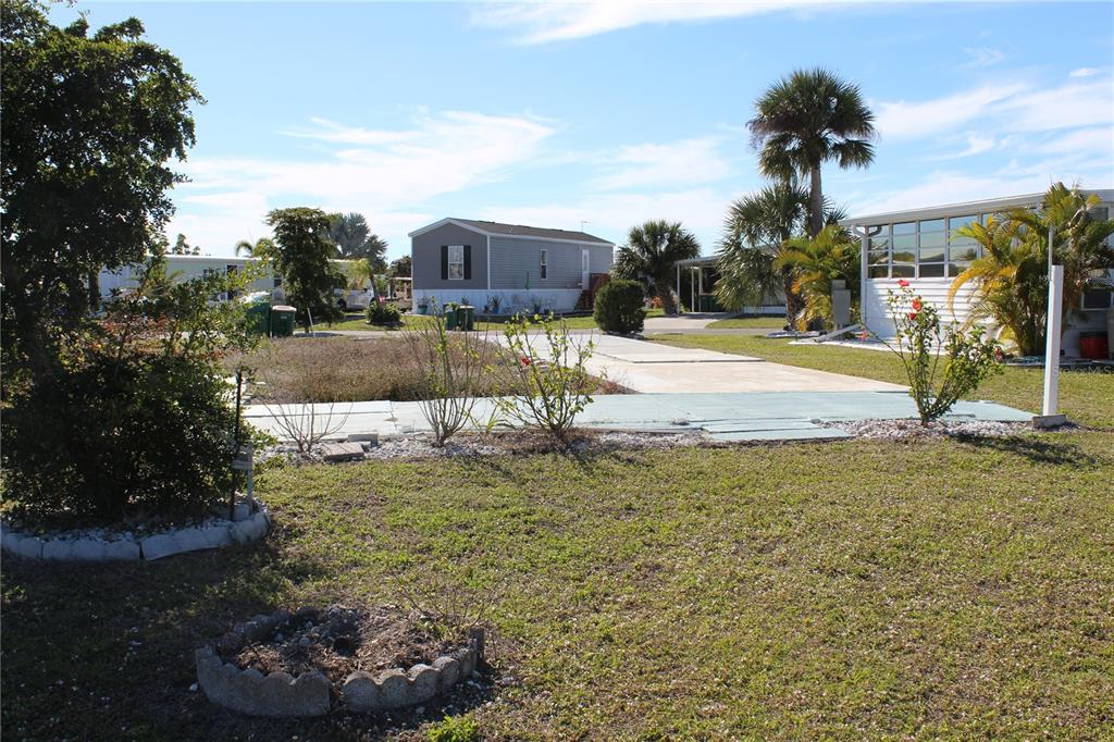 A vacant lot with a concrete pad in a mobile home community under a blue sky — 7392 HESTON STREET, PORT CHARLOTTE, FL