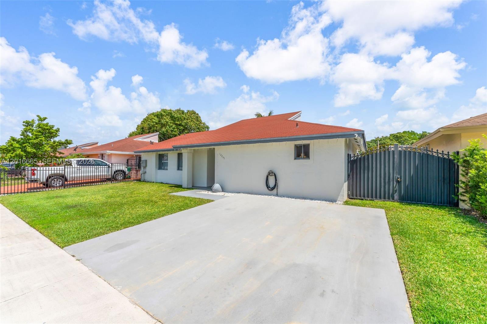 A single-story house with a red roof, white exterior, and a concrete driveway — 12247 SW 203rd St, Miami FL 33177, MIAMI, FL