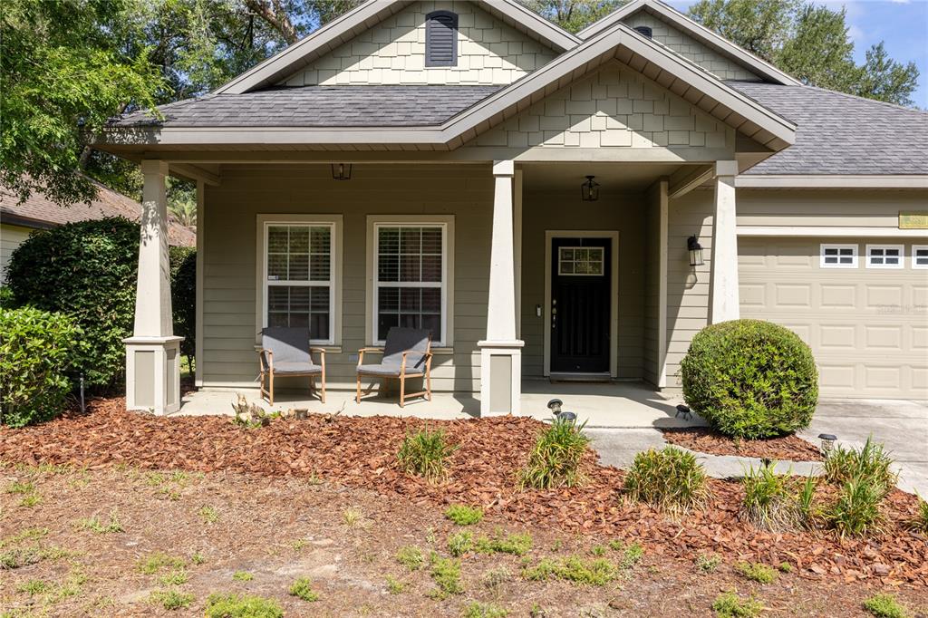 A single-story house with a tan exterior, a two-car garage, and a covered front porch — 7550 SW 81ST WAY, GAINESVILLE, FL