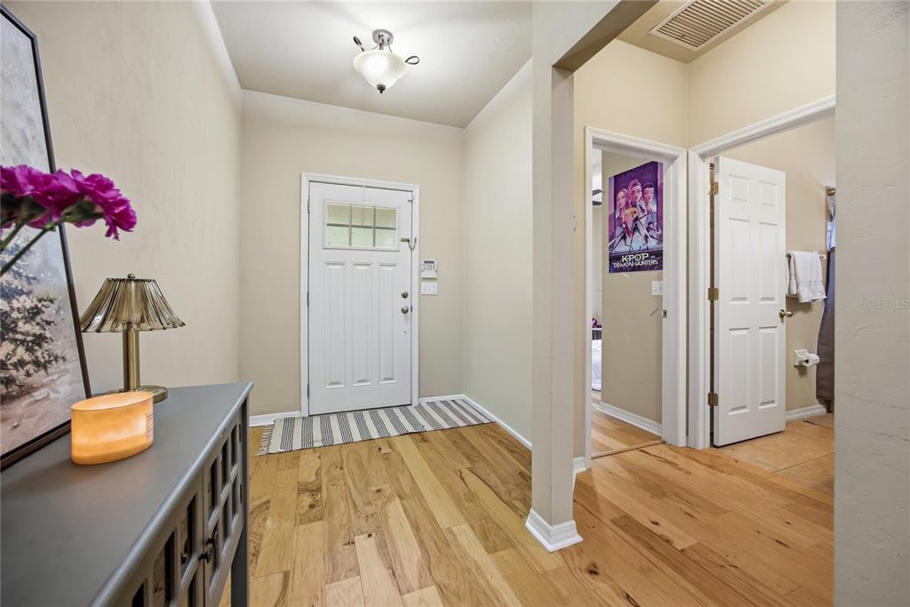 A dark brown front door with a window sits between light green horizontal siding walls — 7550 SW 81ST WAY, GAINESVILLE, FL