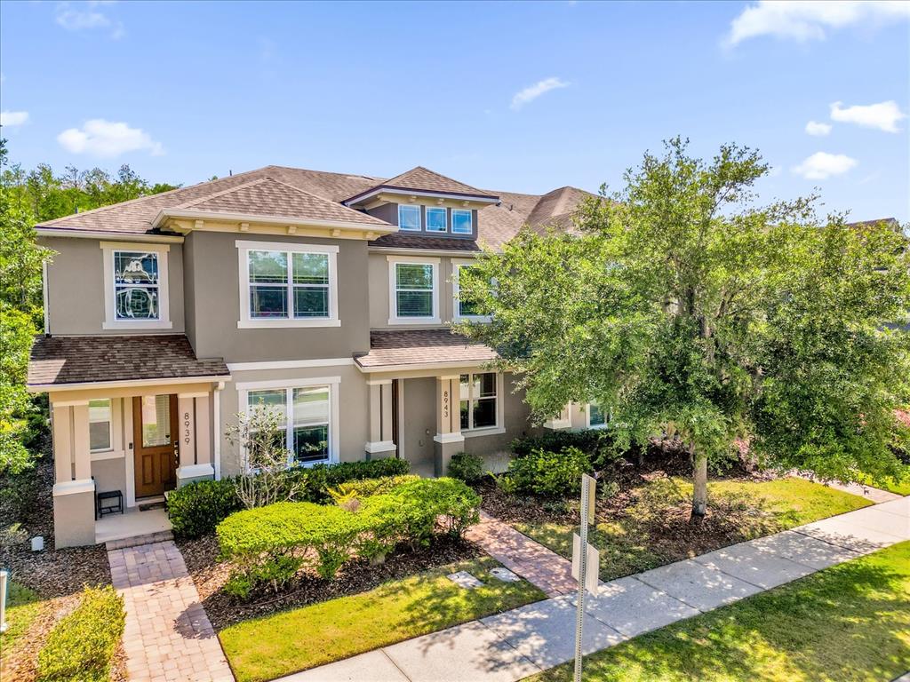 An exterior view of a two-story townhouse with a brown roof and gray siding — 8943 HILDRETH AVENUE, ORLANDO, FL