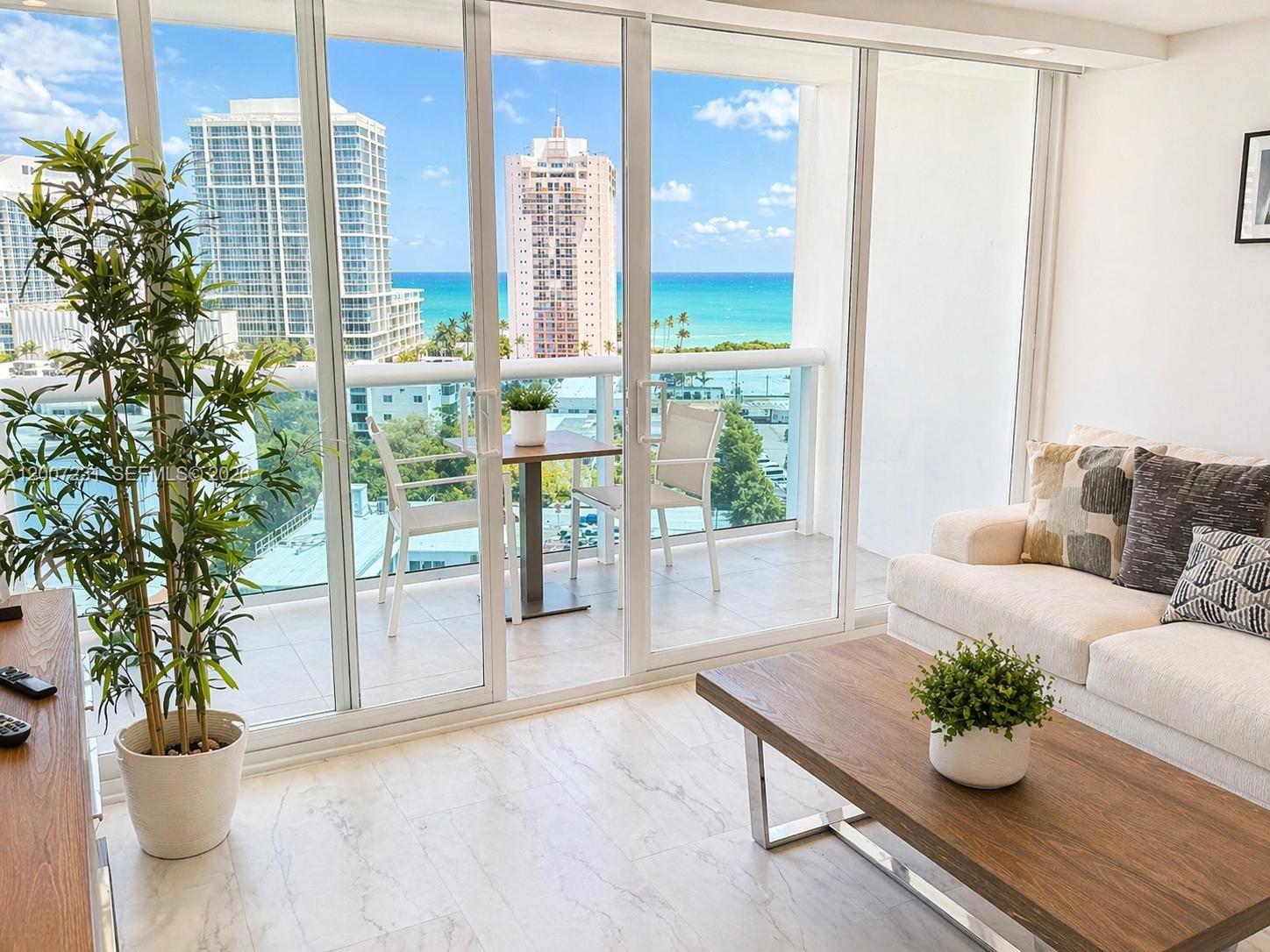 A living room with a balcony, ocean view, marble floors, and a modern coffee table — 6770 Indian Creek Dr # 12T, Miami Beach FL 33141, MIAMI BEACH, FL