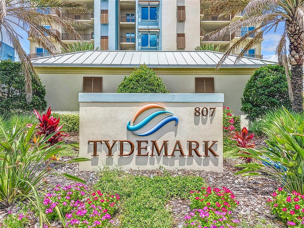 A sign for Tydemark stands in front of a multi-story building with palm trees — 807 S ATLANTIC AVENUE UNIT 303, NEW SMYRNA BEACH, FL