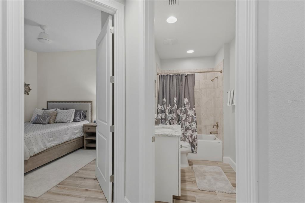 A view through a doorway shows a bedroom and an adjacent bathroom with a shower — 807 S ATLANTIC AVENUE UNIT 303, NEW SMYRNA BEACH, FL
