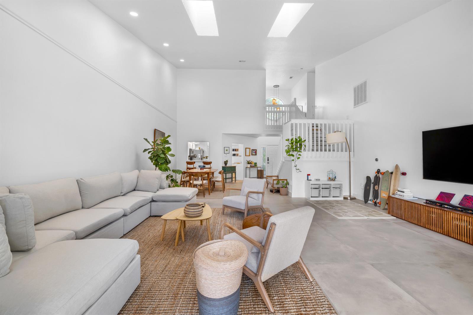 A spacious, high-ceilinged living room features a large sectional sofa, neutral decor, and tile flooring — 4117 W Palm Aire Drive # B2, Pompano Beach FL 33069, POMPANO BEACH, FL