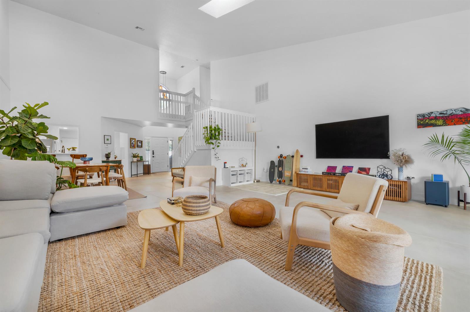 A bright, open-concept living room features high ceilings, a lofted staircase, and neutral furnishings — 4117 W Palm Aire Drive # B2, Pompano Beach FL 33069, POMPANO BEACH, FL