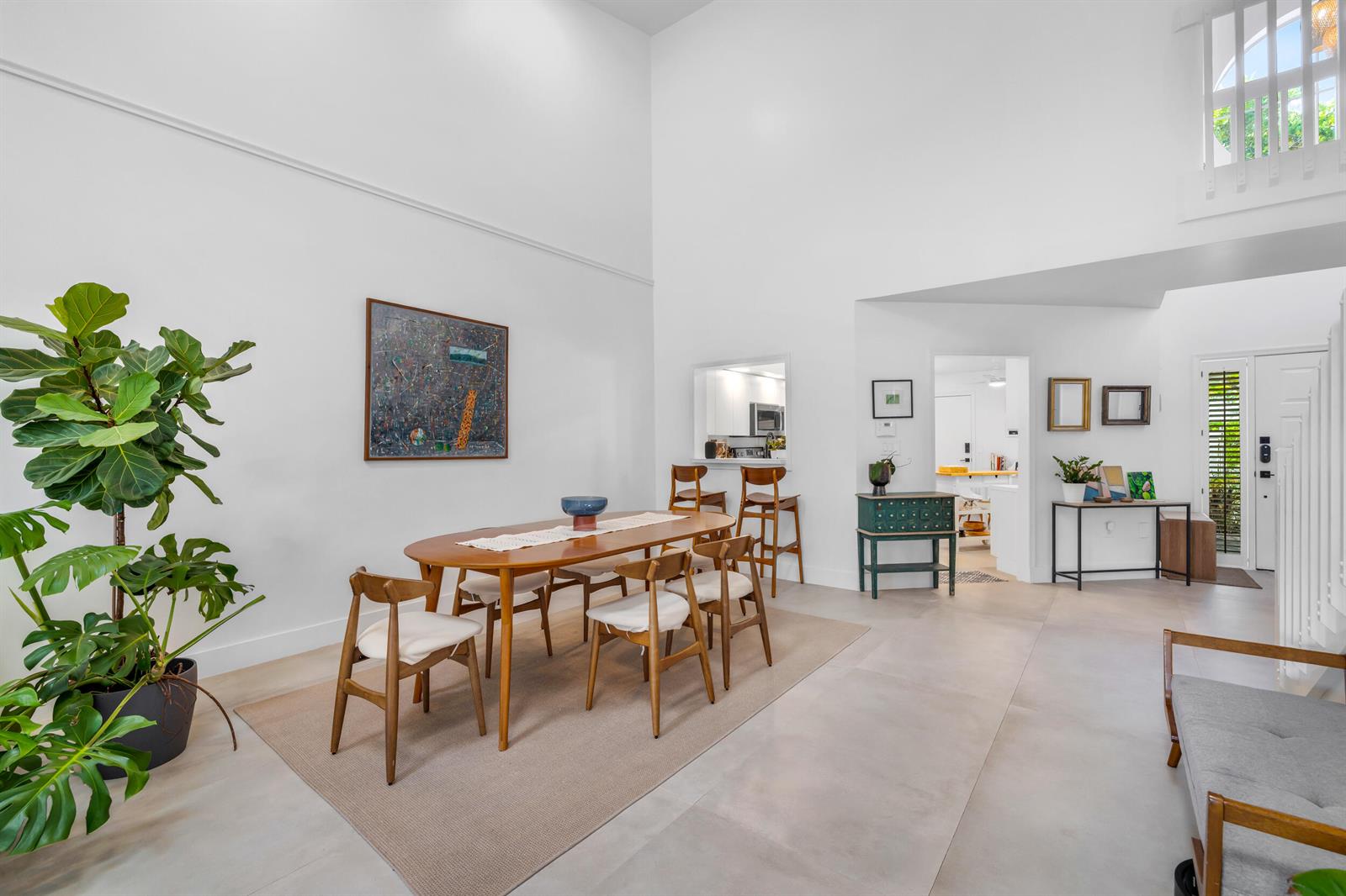 A dining area with a wooden table and chairs sits under a high vaulted ceiling — 4117 W Palm Aire Drive # B2, Pompano Beach FL 33069, POMPANO BEACH, FL