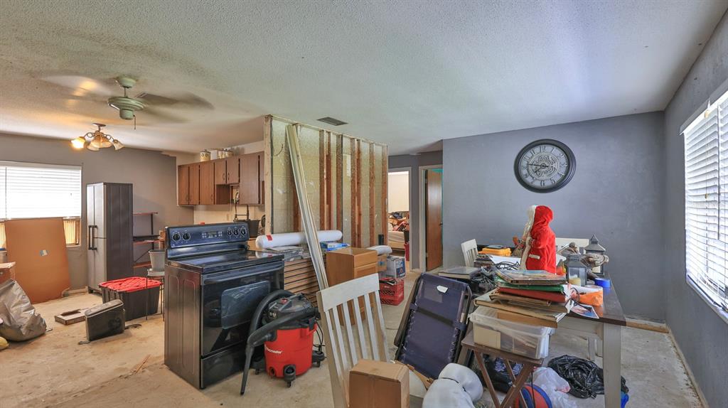 An open-concept room features a kitchen area with exposed wall studs and a dining space — 1863 FERN PALM DRIVE, EDGEWATER, FL