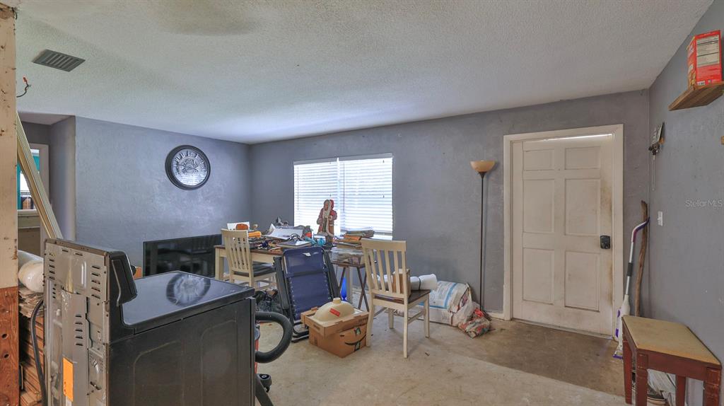 A room with gray walls, a white door, a dining table, and a black appliance — 1863 FERN PALM DRIVE, EDGEWATER, FL