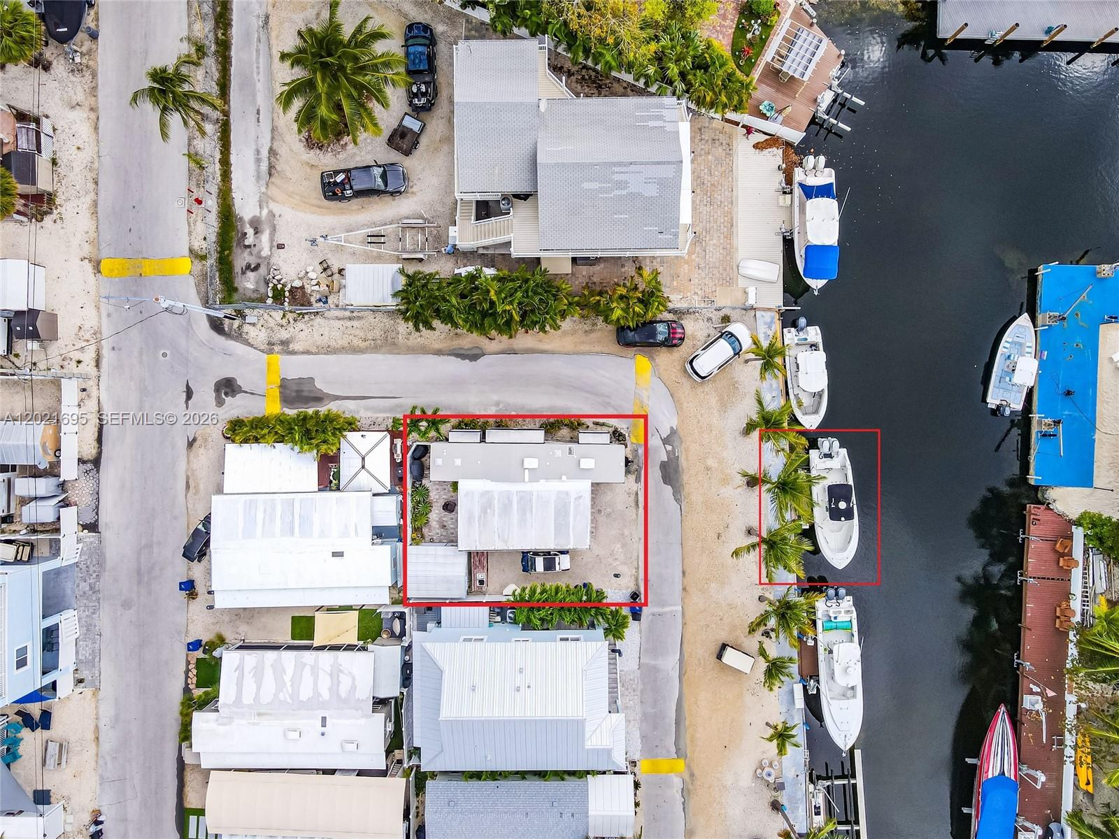 An aerial view shows a residential property with a boat docked in the canal — 325 Calusa St #252, Key Largo FL 33037, KEY LARGO, FL