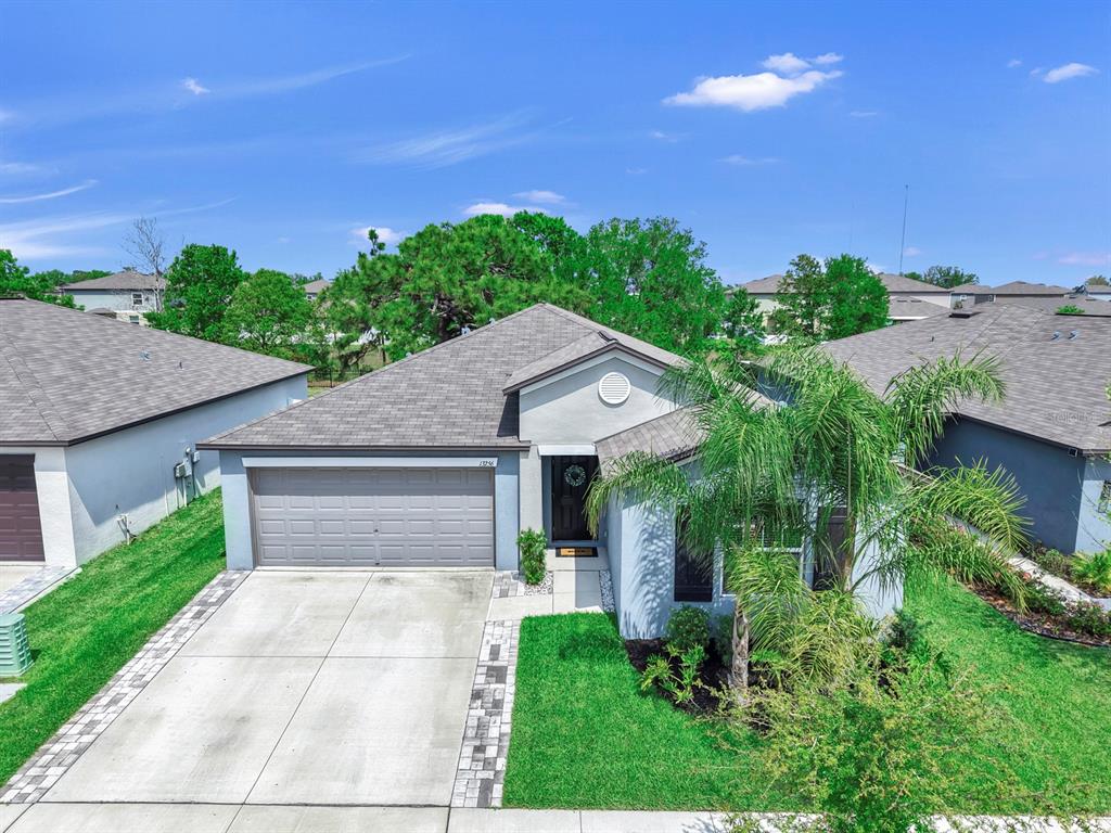 An aerial view of a single-story suburban house with a gray garage and palm tree — 13256 GREAT PLAINS DRIVE, RIVERVIEW, FL