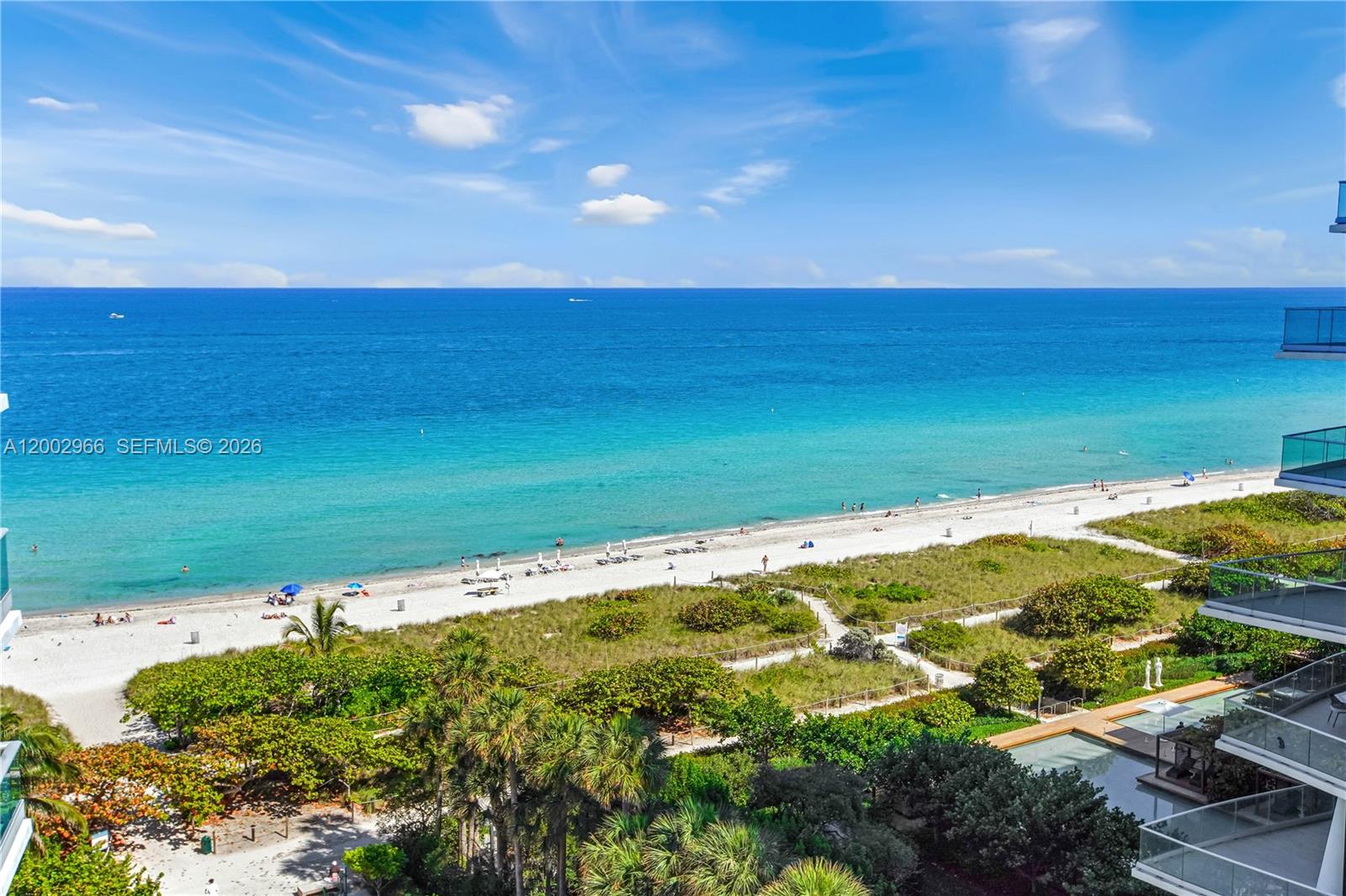 An elevated view of a sandy beach and ocean from a building balcony — 9401 Collins Ave # 1004, Surfside FL 33154, SURFSIDE, FL