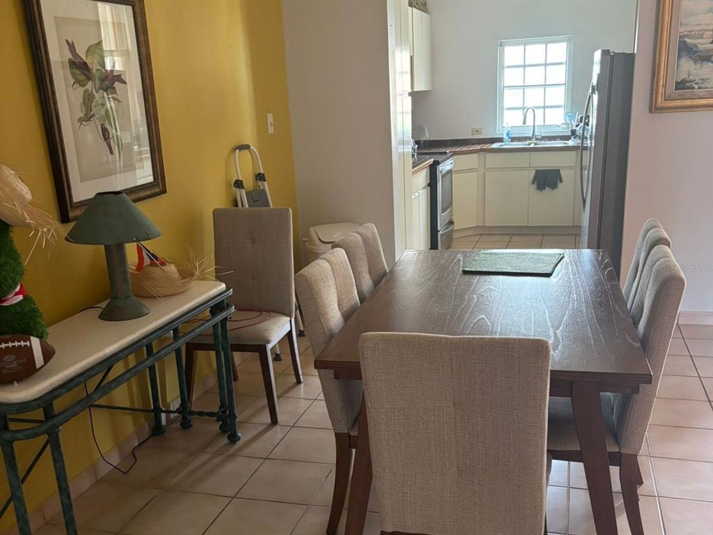 A dining area with a wooden table and chairs sits adjacent to a kitchen — 150 SE CANDELERO DRIVE DRIVE UNIT 712, HUMACAO, PR