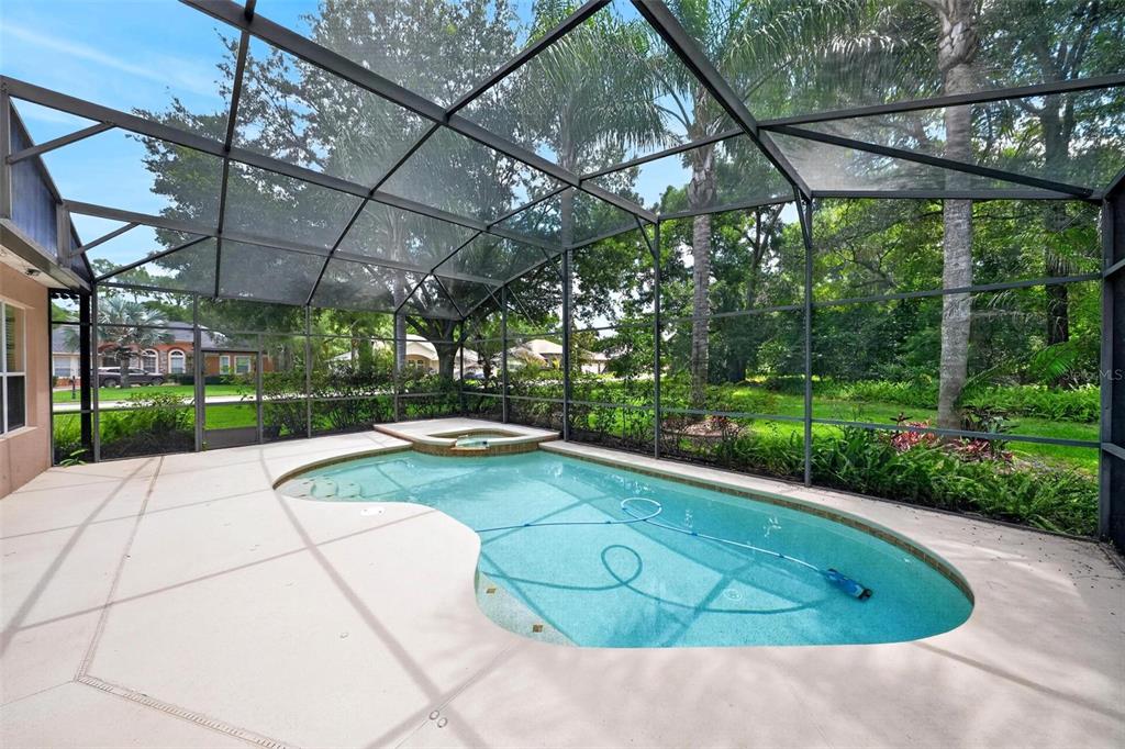 A screened-in swimming pool and attached spa sit on a concrete patio in a backyard — 4385 SEA ROCK COURT, APOPKA, FL