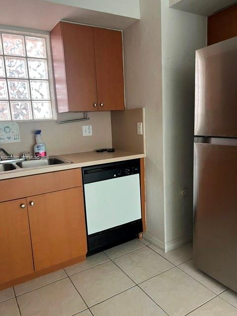A kitchen features wood cabinets, a stainless steel refrigerator, and a black dishwasher — 650 Palm Ave # A2, Hialeah FL 33010, HIALEAH, FL