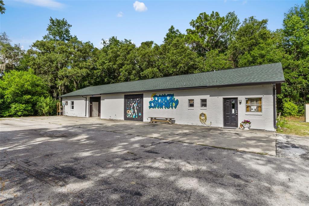 A single-story white building with a green roof and a large parking lot in front — 6950 W HOMOSASSA TRAIL, HOMOSASSA, FL