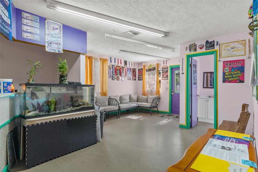A room with light pink walls, a large fish tank, seating, and numerous wall-mounted awards — 6950 W HOMOSASSA TRAIL, HOMOSASSA, FL