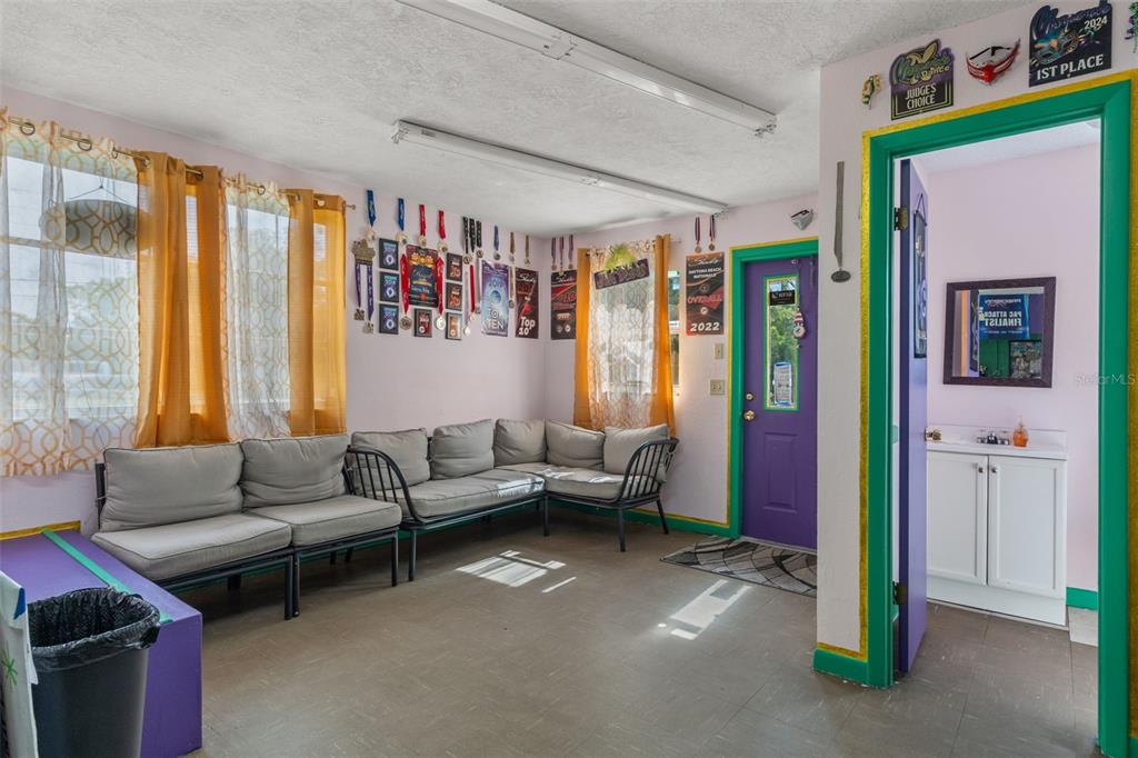 A room with light-colored walls, gray sectional seating, yellow curtains, and a purple door — 6950 W HOMOSASSA TRAIL, HOMOSASSA, FL