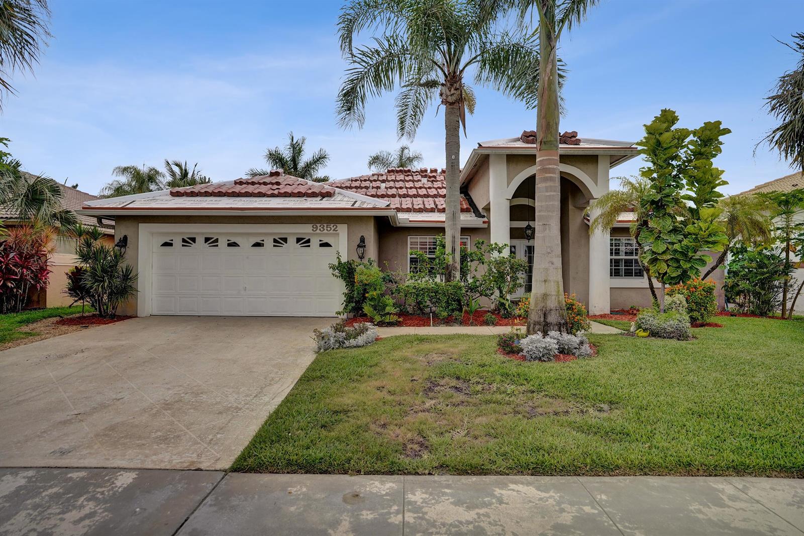 A single-story house with a tile roof, a two-car garage, and a palm tree — 9352 Cascade Court, Boynton Beach FL 33437, BOYNTON BEACH, FL