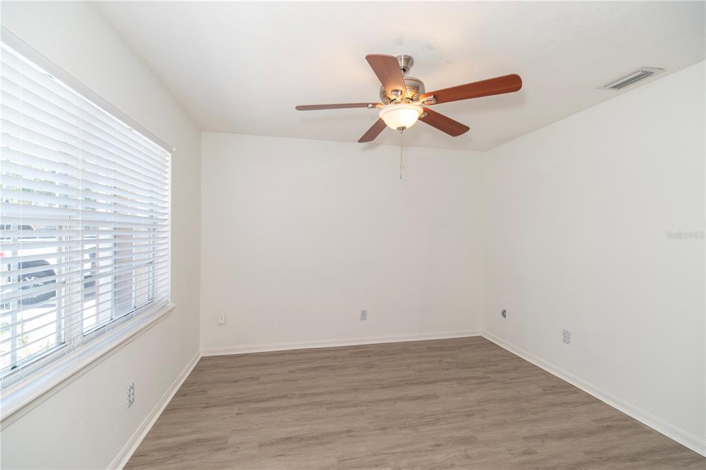 An empty room with white walls, wood-look flooring, a ceiling fan, and a window with blinds — 344 CERVANTES DRIVE, KISSIMMEE, FL