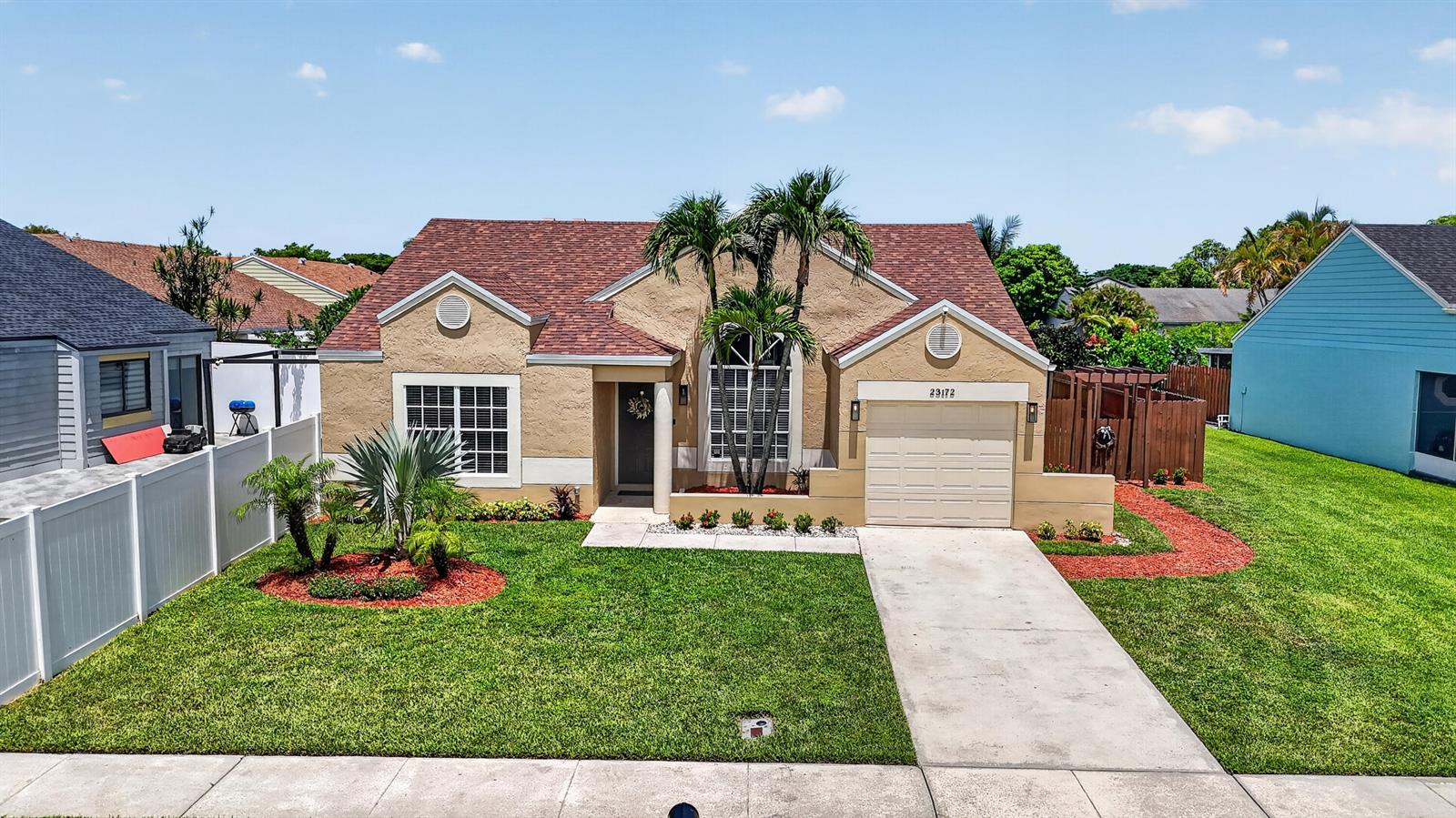 A single-story tan house with a brown shingled roof, a garage, and a front lawn — 23172 Bentley Place, Boca Raton FL 33433, BOCA RATON, FL