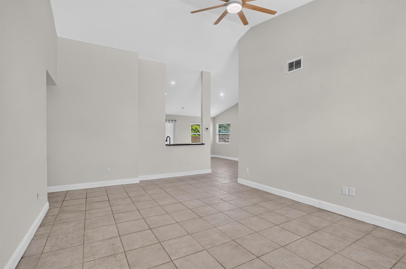 An empty room with light-colored walls, tile flooring, and a ceiling fan — 23172 Bentley Place, Boca Raton FL 33433, BOCA RATON, FL