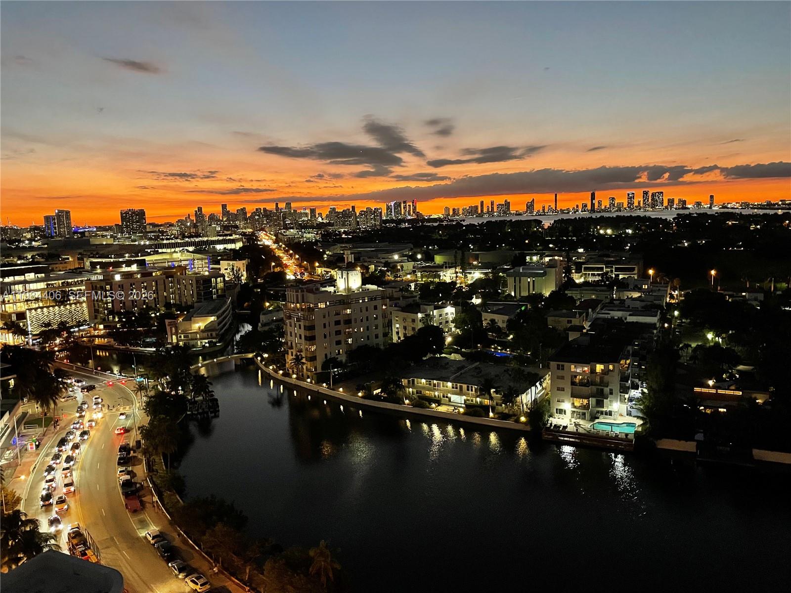An elevated night view of a city skyline over a canal with illuminated waterfront buildings — 2555 Collins Ave # 2402, Miami Beach FL 33140, MIAMI BEACH, FL