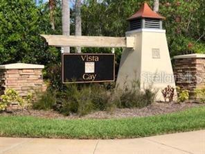 A stone and stucco entrance sign for Vista Cay stands surrounded by landscaping and trees — 948 VISTA CAY COURT, BRANDON, FL