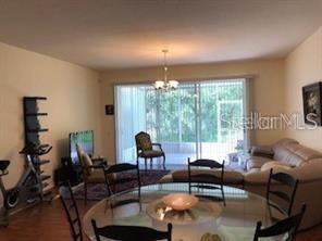 A living and dining area features a glass table, a sofa, and sliding glass doors — 948 VISTA CAY COURT, BRANDON, FL