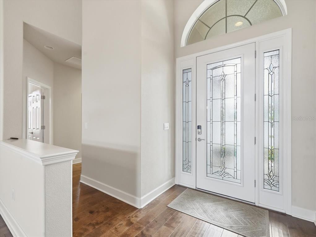 An entryway features a white front door with glass panels, a transom window, and hardwood floors — 2514 SUMMERDALE COURT, CLEARWATER, FL