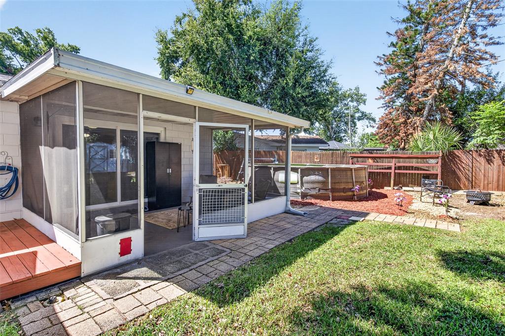 A screened-in porch with a brick patio and an above-ground pool in the backyard — 2021 OLIVER PLACE, WINTER HAVEN, FL