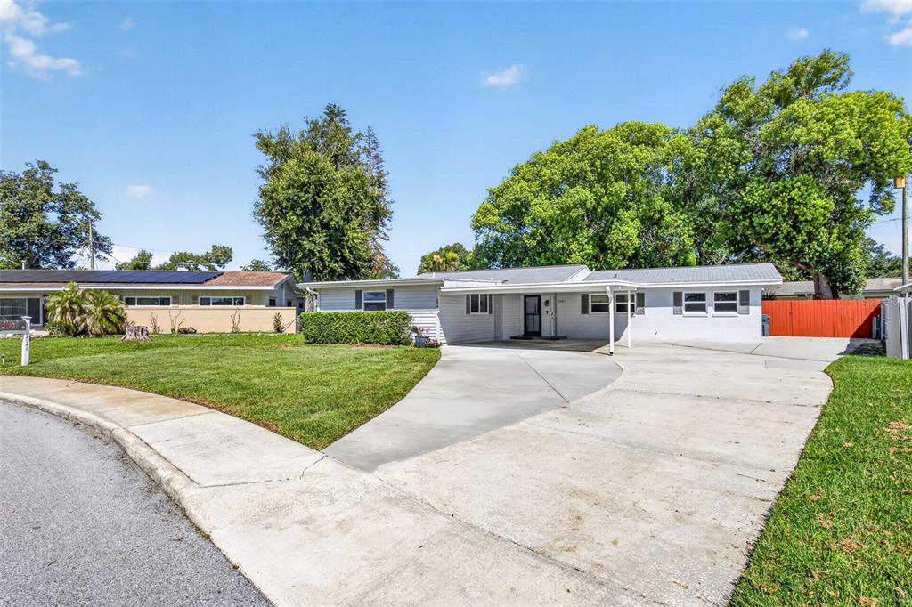 A single-story house with a white exterior, a concrete driveway, and a large front lawn — 2021 OLIVER PLACE, WINTER HAVEN, FL