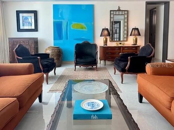 A living room features orange sofas, black armchairs, a glass coffee table, and blue artwork — 76 KINGS COURT STREET UNIT 902, SAN JUAN, PR