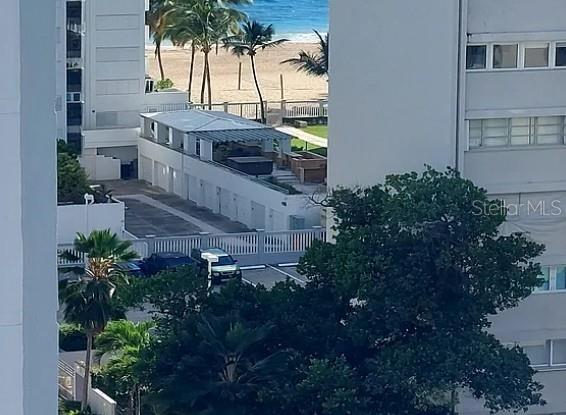 An elevated view shows a beachside parking area with a small structure and palm trees — 76 KINGS COURT STREET UNIT 902, SAN JUAN, PR
