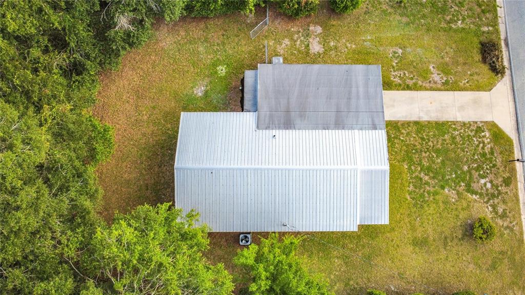 An aerial view shows a house with a metal roof and an adjacent concrete driveway — 1504 NW 19TH COURT, OCALA, FL