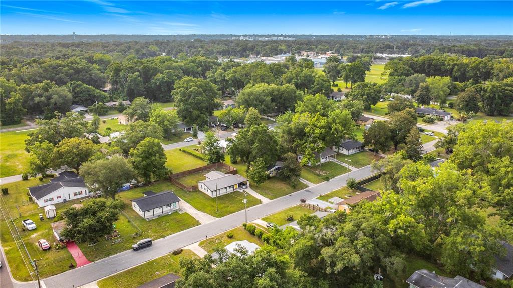 An aerial view shows a residential neighborhood with several single-story houses surrounded by trees — 1504 NW 19TH COURT, OCALA, FL